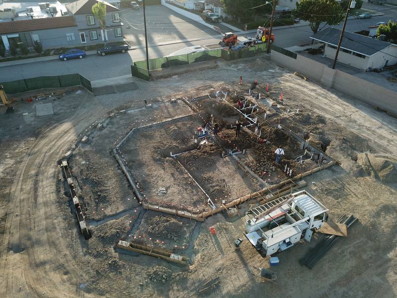 Aerial view of a building pad with underground plumbing rough-in and footings