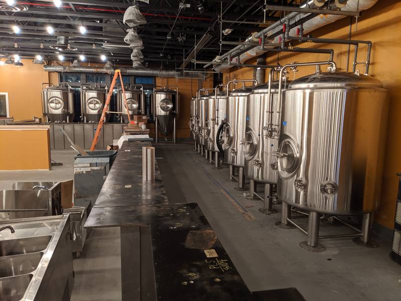 Pedals and Pints Brewing under construction, with a row of stainless steel fermentation tanks