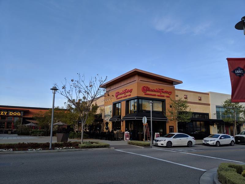 Exterior of a Cheesecake Factory restaurant at a shopping center on a clear morning