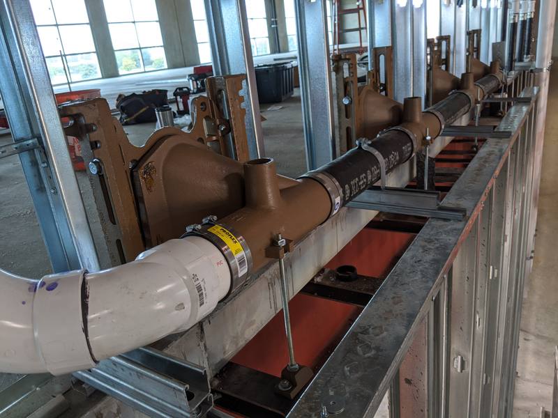 Cast-iron carriers and waste piping inside a metal-stud wall