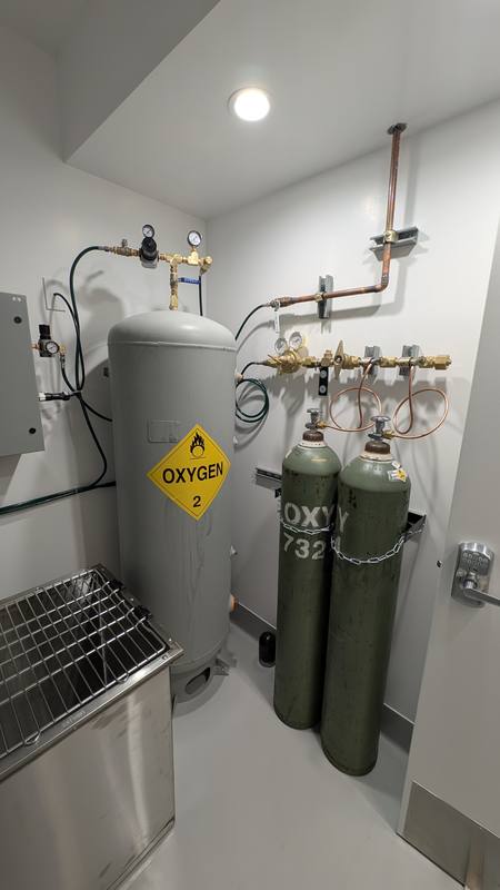 Gas room with an oxygen dewar, gas cylinders and copper distribution piping
