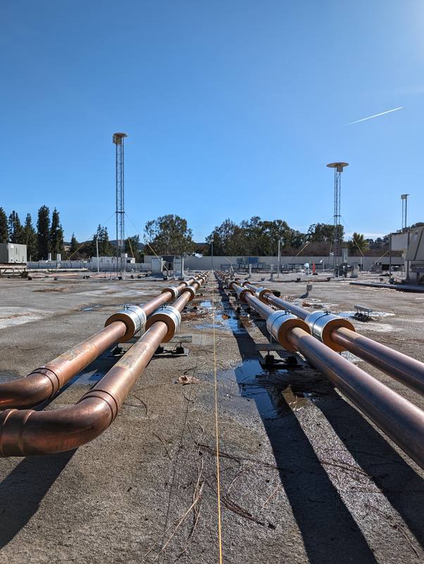 Long parallel runs of insulated copper pipe across a commercial roof
